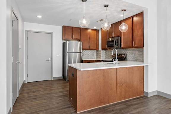 A kitchen with wooden cabinets and a stainless steel refrigerator.