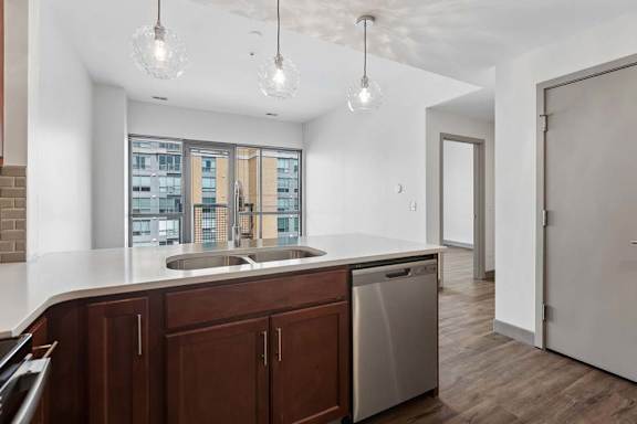 A kitchen with brown cabinets and a stainless steel dishwasher.