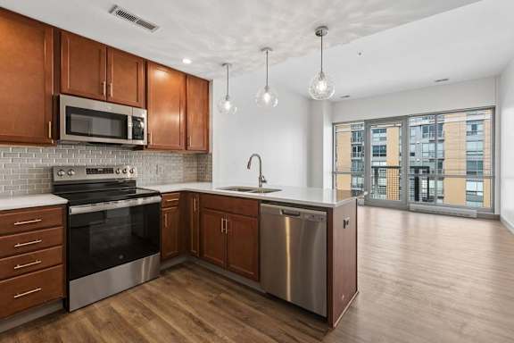 A modern kitchen with wooden cabinets and stainless steel appliances.