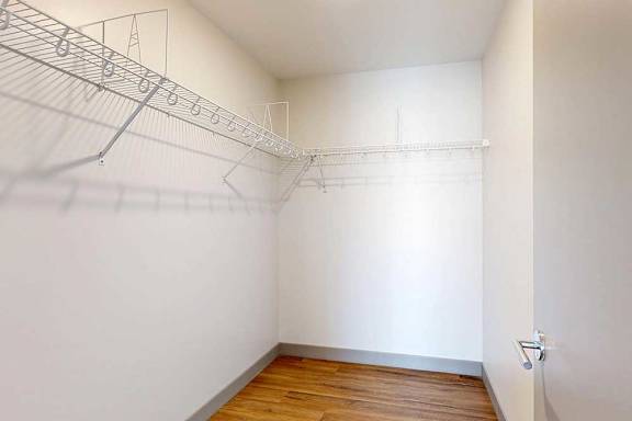 An oversized walk-in closet with several built-in wire shelves.
