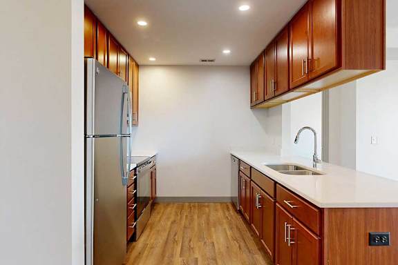 A kitchen with warm wood cabinets, granite countertops, and stainless steel appliances.