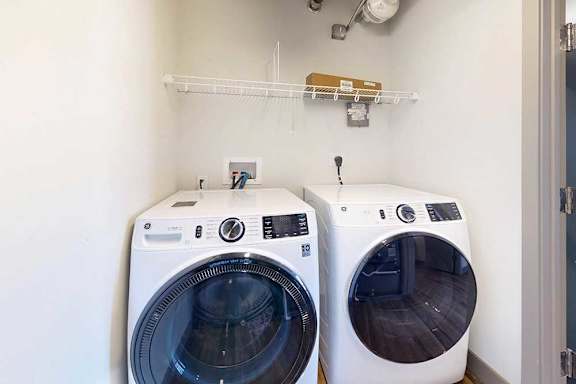 An in-unit full-sized washer and dryer in a laundry room.