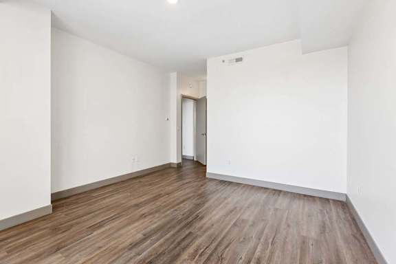 A room with wooden flooring and white walls.