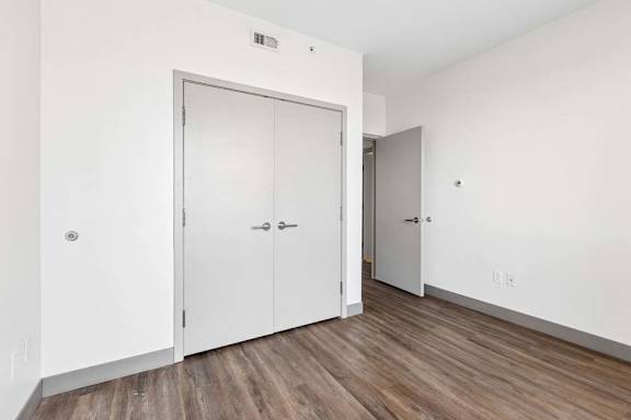 A room with a white door and a white wall.