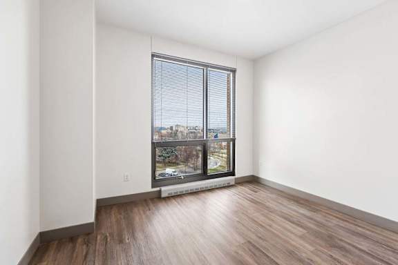 A room with a large window overlooking a cityscape.