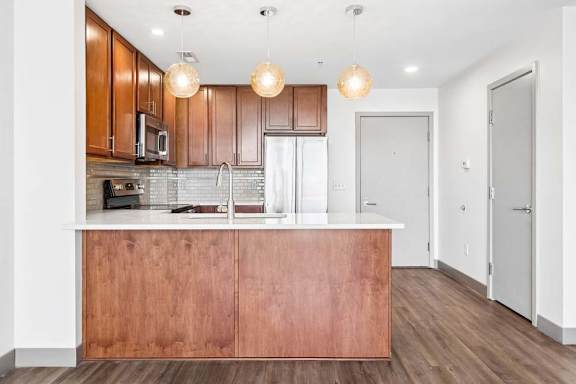 A kitchen with wooden cabinets and a white counter.