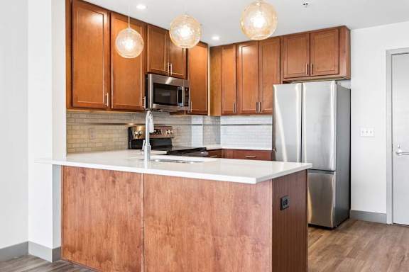 A kitchen with wooden cabinets and a white countertop.