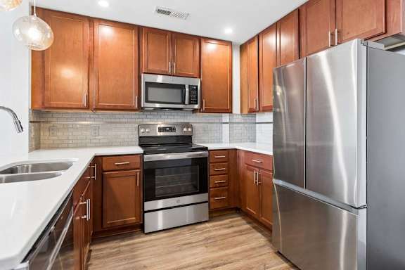 A kitchen with wooden cabinets and stainless steel appliances.