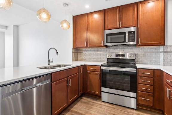 A modern kitchen with wooden cabinets and stainless steel appliances.