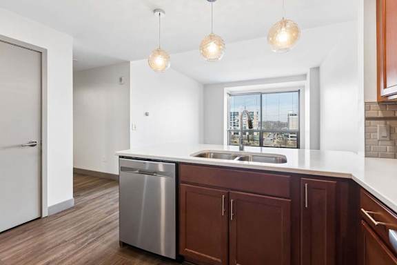 A kitchen with brown cabinets and a stainless steel dishwasher.