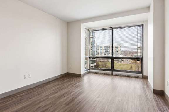 A room with a large window and wooden flooring.