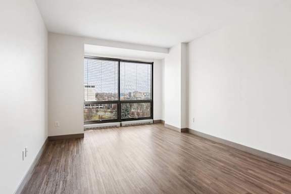 A room with a large window and wooden flooring.