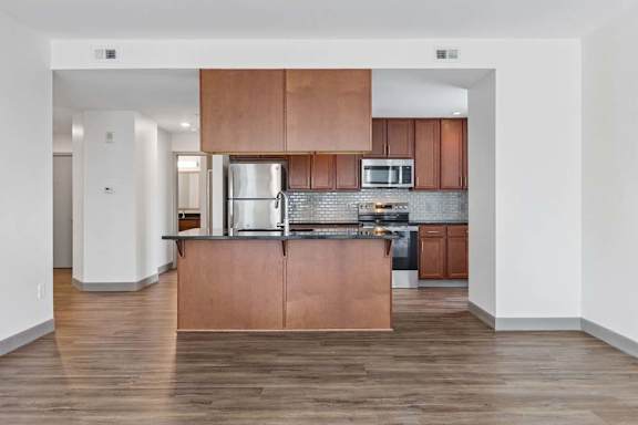 A kitchen with wooden floors and a white refrigerator.