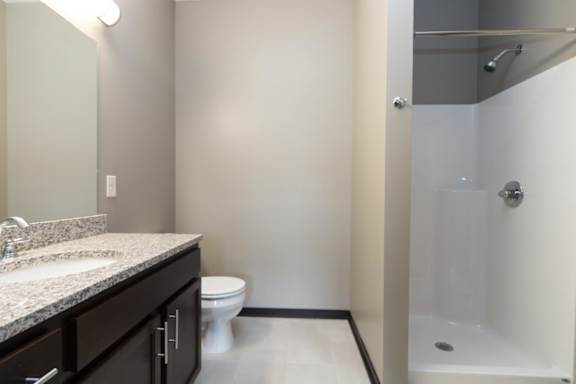 A bathroom with a sink, toilet, and shower.