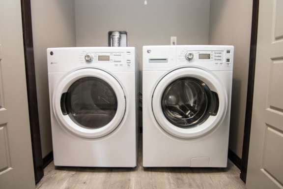 Two front loading washing machines in a laundry room.
