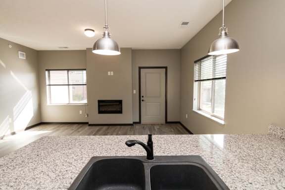 A kitchen with a black sink and granite countertop.