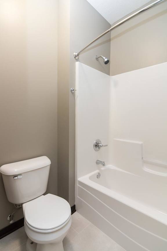 A white toilet and bathtub in a bathroom.