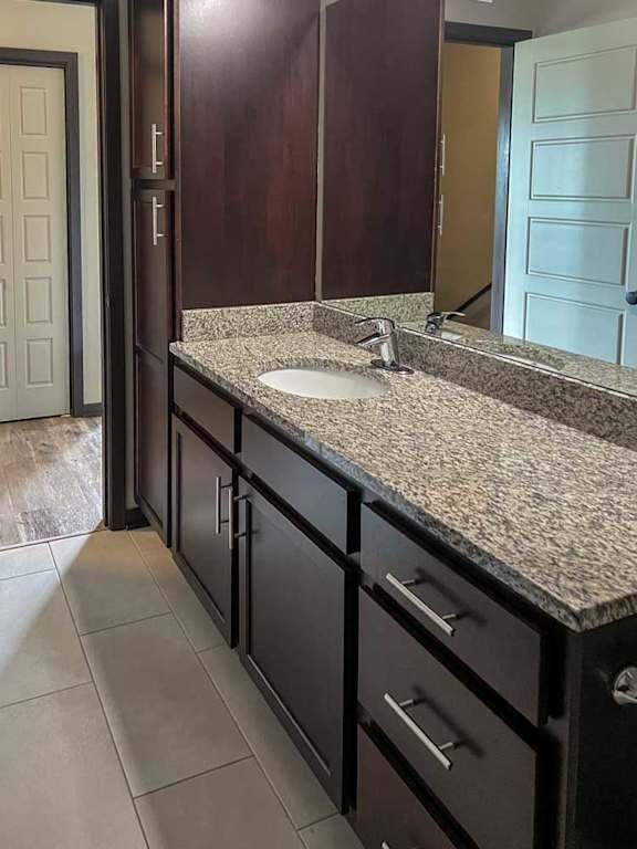 a bathroom with a granite vanity sink and a mirror