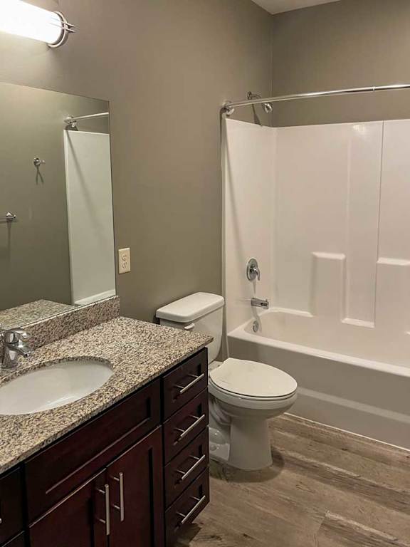 a bathroom with a granite vanity sink and a tub shower