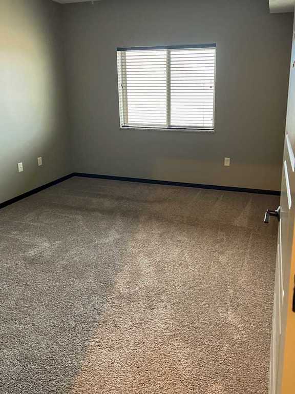 a bedroom with carpeted flooring and a window