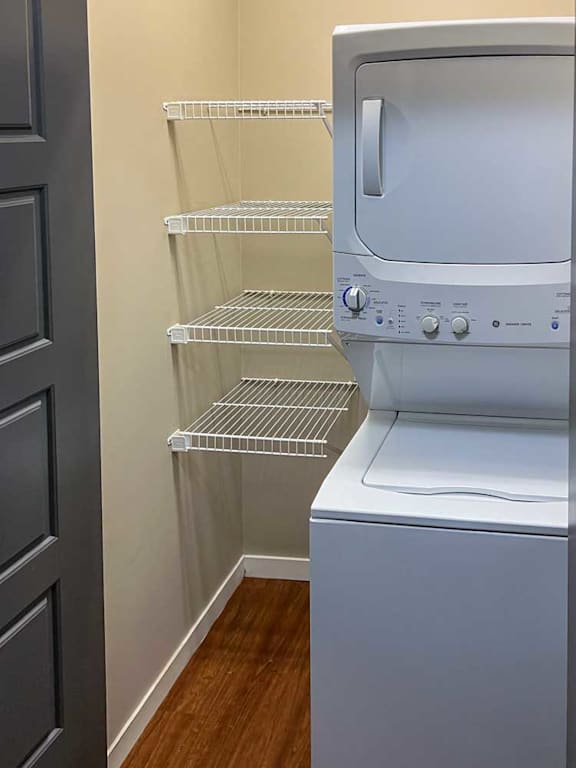 a stackable washer and dryer in a laundry room with built-in shelving