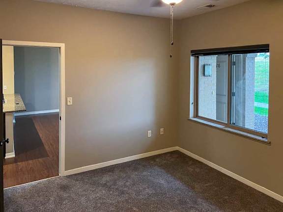 a bedroom with carpeted flooring, a window, and a ceiling fan