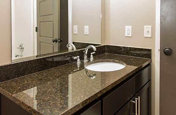 a bathroom vanity sink with a granite counter top