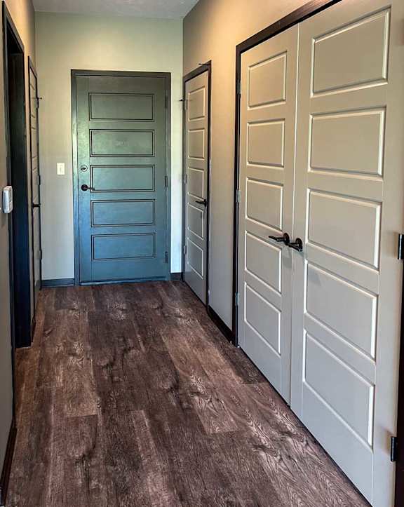 a hallway in the front entry with a laundry closet and coat closet