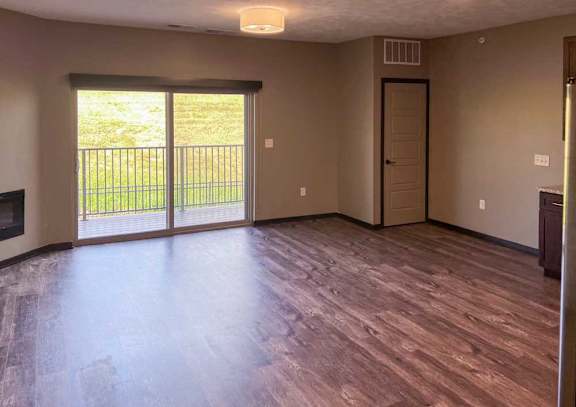 a living room with a sliding glass door to the balcony, and a closet