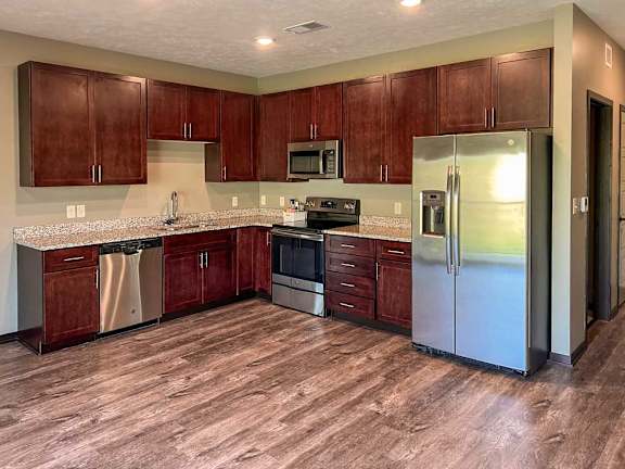 a kitchen with warm brown wooden cabinets and stainless steel appliances