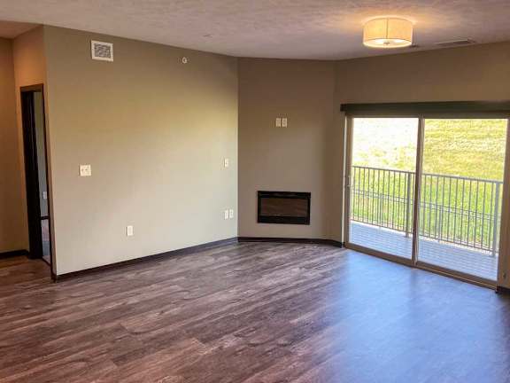 a living room with a fire place and sliding glass doors to the balcony