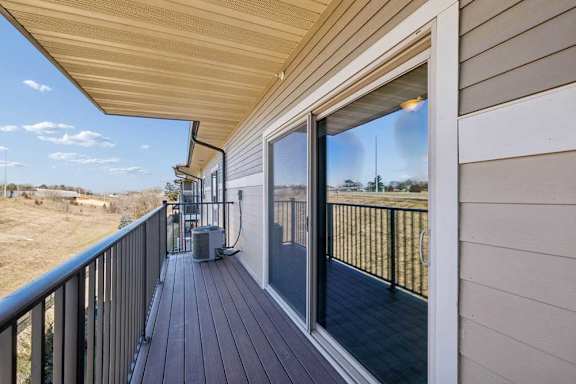 A balcony with a sliding glass door and a black railing.
