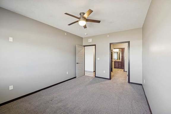 A room with a ceiling fan and carpeted floor.