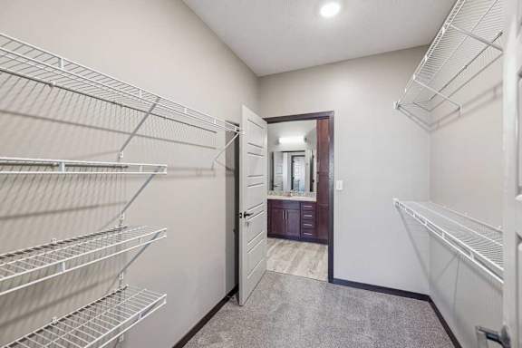 A walk-in closet with metal shelving and a mirrored door.