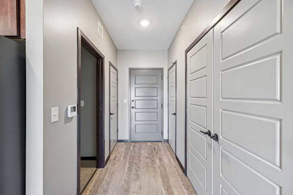 A hallway with a white door and a black door.
