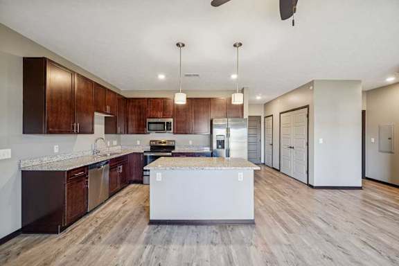 A modern kitchen with dark wood cabinets and a central island.
