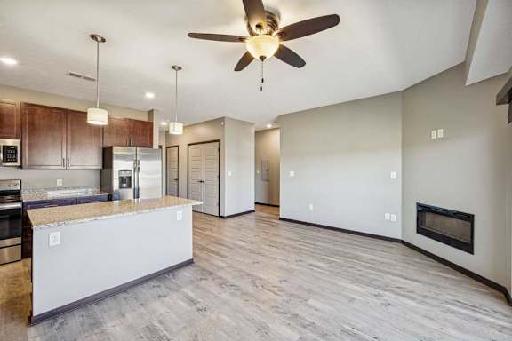 A modern kitchen with a large island and a fireplace in the living room.