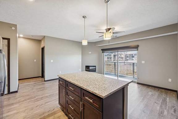 A kitchen with a granite countertop and a refrigerator.