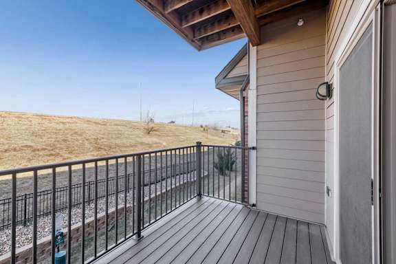 A balcony with a black railing and a white door.