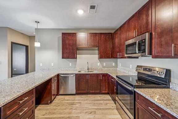 A kitchen with wooden cabinets and granite countertops.