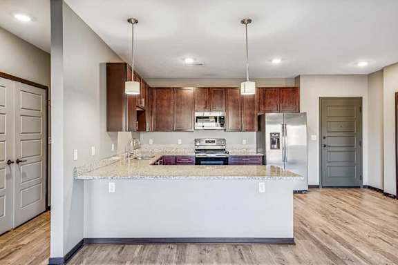 A kitchen with a marble countertop and wooden cabinets.