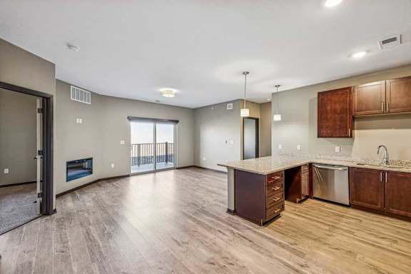 A spacious kitchen and living room with wooden floors and modern appliances.