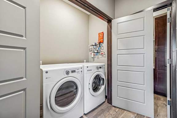 Two white front loading washing machines in a laundry room.