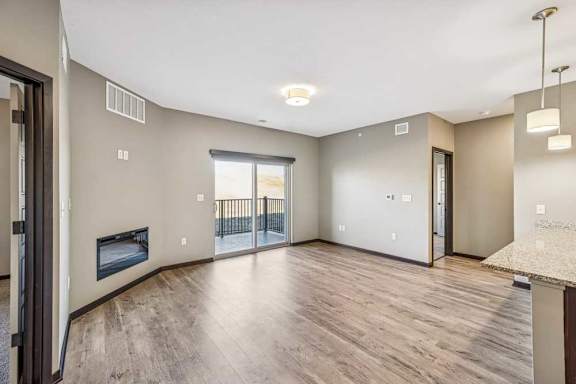 A spacious living room with a fireplace and sliding glass doors.