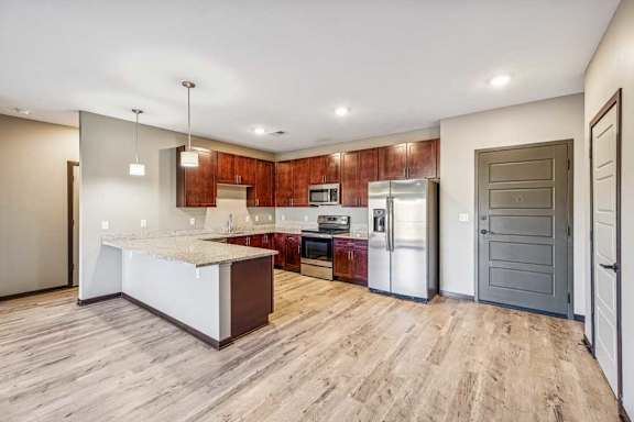 A kitchen with a white island and wooden cabinets.