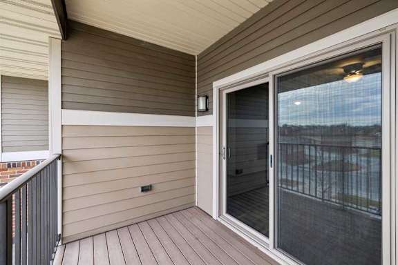 A balcony with a sliding glass door leading to a patio.