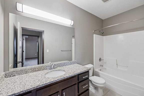 A bathroom with a sink, toilet, and bathtub.