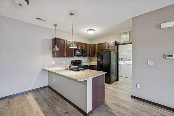 A kitchen with a granite countertop and wooden cabinets.