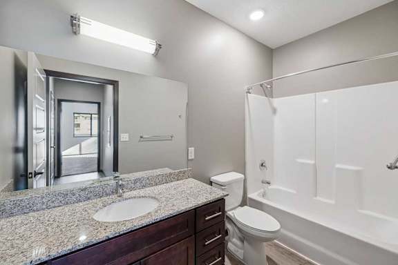 A bathroom with a sink, toilet, and bathtub.