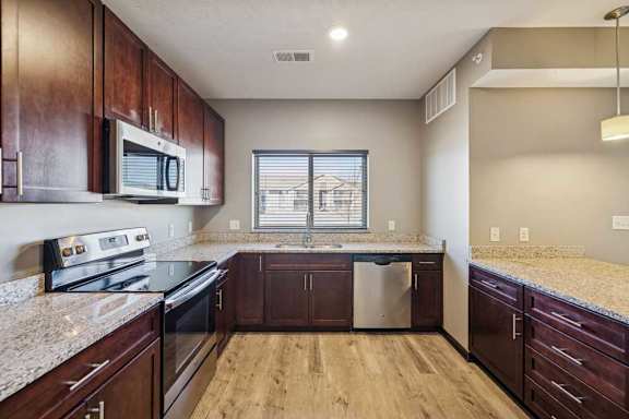A kitchen with wooden cabinets and granite countertops.